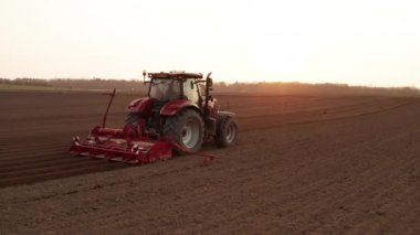  Gün batımında tarımda çalışan kırmızı traktör..