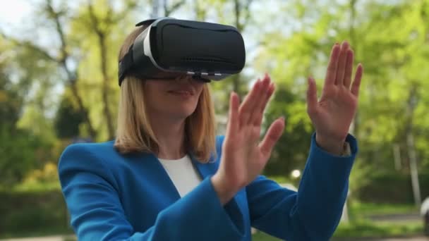 Деловая женщина в виртуальных очках касается симуляционного экрана в парке — стоковое видео
