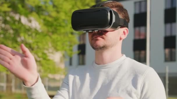 Mann trägt Virtual-Reality-Headset und steuert das Interface in Augmented Reality. — Stockvideo