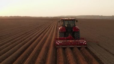 Ağır traktör patates ekmek için yatak yapmak için saban kullanır. Tohum ekme mevsiminin başlangıcı.