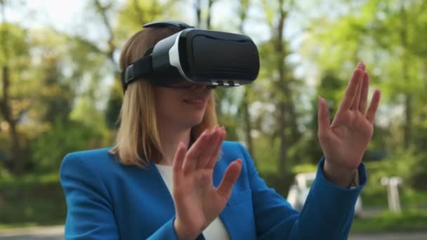 Деловая женщина в виртуальных очках касается симуляционного экрана в парке — стоковое видео
