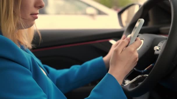 Oldalnézet üzletasszony ül a kocsiban, és használja a mobiltelefon — Stock videók