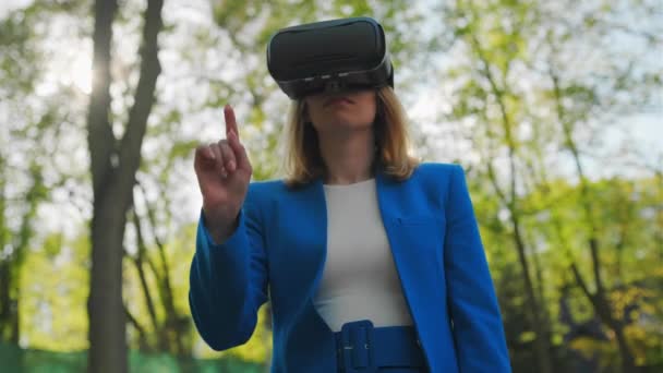 Geschäftsfrau steuert die virtuelle Oberfläche, indem sie mit dem Finger Tasten in einer VR-Brille drückt — Stockvideo