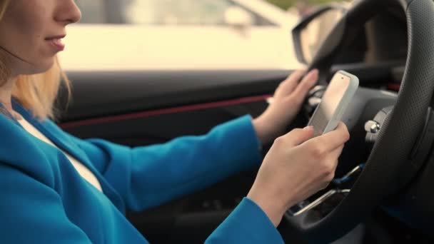 Close up young woman sitting in the car and swiping her mobile phone — Stock Video