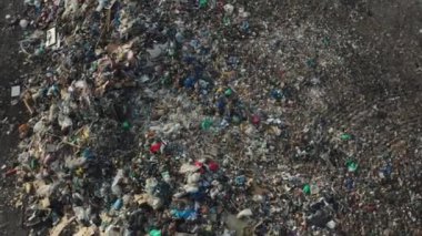 Kuşlar büyük şehir çöplüğünün üzerinde plastik atık yığınlarıyla daireler çiziyor. Kırsal alanda büyük bir çöp yığını. Doğa ve çevre kirliliği hava görüntüsü