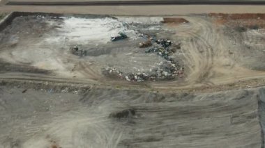 Kırsal alanda atık ve plastik yığınlarıyla çöplük. Çöp kamyonu, kentsel toplumların hava görüntüsünden toplanan çöpleri fırlatıyor