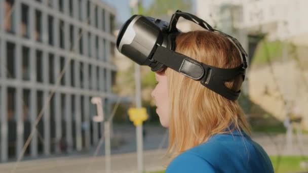 佩戴虚拟现实耳机并开始在商务中心附近使用虚拟界面的女性 — 图库视频影像