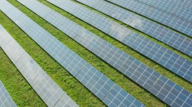 Güneş panelleri güneşli bir günde elektrik istasyonunda yeşil enerji üretir. Çağdaş fotovoltaik modüller kırsal alan hava görünümünde uzun satırlarda kurulu