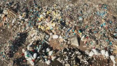 Endüstriyel üretim tesislerinden kaynaklanan büyük plastik atık yığınlarının yol açtığı çevre kirliliği. Güneşli bir günde çöplerle dolu bir çöp yığını.