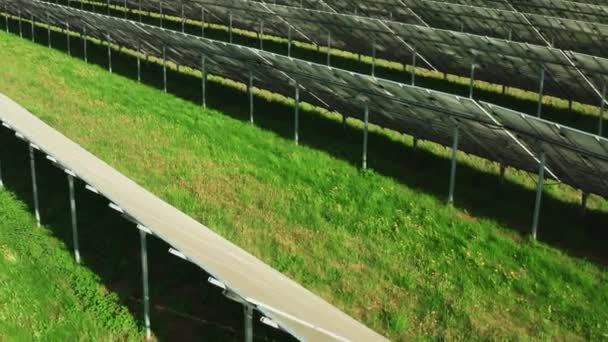 在草地上建造的一排排太阳能电池在农村地区产生绿色能源 晴天时电站的未来光伏太阳能电池板 — 图库视频影像