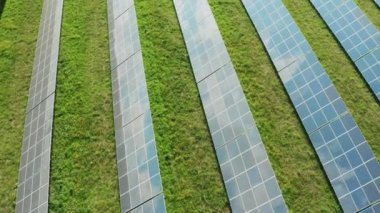 Fotovoltaik güneş hücreleri, alandaki elektrik istasyonunda yüzeyinde beyaz bulutlar bulunan mavi gökyüzünü yansıtır. Modern güneş panelleri yeşil enerji gökyüzü görüntüsü oluşturur