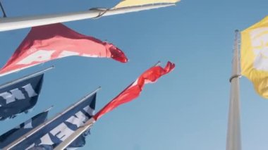 Bottom view of colourful IKEA flags waving in the wind against sky, July 2022, Prague, Czech Republic.