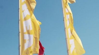 Yellow and red IKEA flags waving in the wind against sky, July 2022, Prague, Czech Republic.