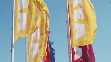 Yellow and red IKEA flags waving in the wind against sky, July 2022, Prague, Czech Republic.