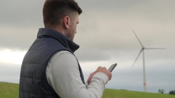 Man Engineer Makes Notes Phone Wind Turbine Operation Closeup Windmill — Stock Video