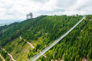 Aerial view of the worlds longest 721 meter suspension footbridge Sky bridge and observation tower the Sky walk in the forest, between mountains, Dolni Morava Ski Resort, Czech Republic. 