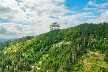 Sky walk observation tower in the forest between mountain hills near Sky Bridge 721 in a sunny summer day, Dolni Morava, Czech Republic. 