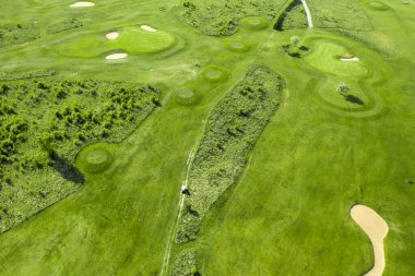 Golf course with sand bunker and green grass, aerial view.