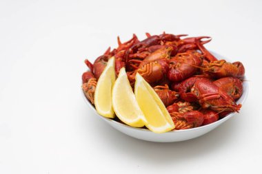 Beyaz arka planda bir tabakta taze kırmızı haşlanmış kerevit yiyeceği. Limonlu sağlıklı deniz ürünleri..