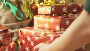 Noel ağacının altında kırmızı kağıt ve altın kurdelelerle süslenmiş kutulara bir yığın hediye koyar. Sahibi kutlama ve parti hazırlıyor.