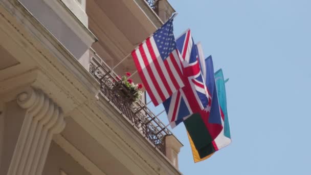Bandeiras Diferentes Países Mundo Onduladas Pelo Vento Varanda Edifício Branco — Vídeo de Stock