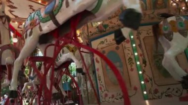 PRAG, CZECH Cumhuriyet - 17 Temmuz 2022: İlginç koltukları ve ışıkları olan eski moda Fransız atlıkarınca. Atlı karınca, tahta atlarla lunaparkta çocuklara biniyor. 