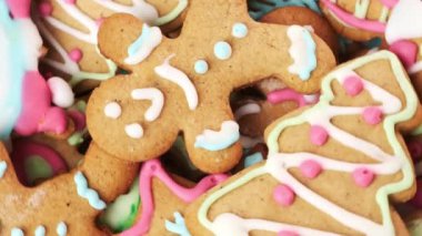 Noel 'i şenlik masasında kutlamak için bir yığın fırında zencefilli ekmek. Çok renkli krema soslu zencefilli ekmekler.