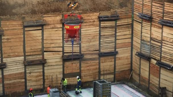 プラハ チェコ共和国 2022年1月22日 クレーンは コンクリートを木製のフォームワークに注ぐためにポンプホースを下げます 高層建築物の建設中の機械のベストコントロール操作の労働者 — ストック動画