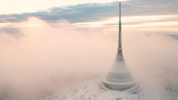 霧の雲に囲まれた森林の山の上に建てられたホテルとジェスト放送塔 リベレツの空中景観の象徴として尖塔を持つ近代的な建物 — ストック動画