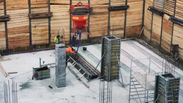 プラハ チェコ共和国 2022年1月22日 ベストの労働者は ポンプホースからコンクリートモルタルを基礎ピットに設置された木製のフォームワークに注ぎます 高層建築物の建設過程 — ストック動画