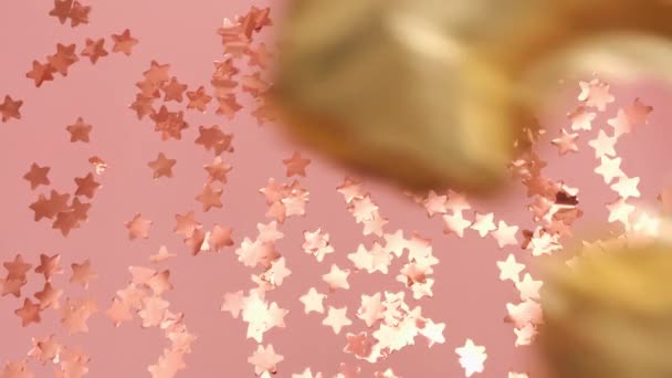 Купа Золотих Кульок Формі Цифр Падає Рожеву Підлогу Розкиданими Зірками — стокове відео