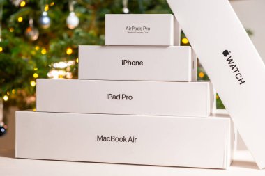 iPhone, saat, AirPods pro, iPad pro, MacBook Air, Apple kalem ve Noel ağacı altında kırmızı bir fiyonk. Noel ve Yeni Yıl partileri için hediyeler, Ekim 2022, Prag, Çek Cumhuriyeti 