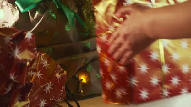 Person Legt Geschmückten Geschenkkarton Mit Goldener Schleife Unter Weihnachtsbaum Für — Stockvideo