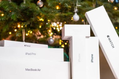 iPhone, saat, AirPods pro, iPad pro, MacBook Air, Apple kalem ve Noel ağacı altında kırmızı bir fiyonk. Noel ve Yeni Yıl partileri için hediyeler, Ekim 2022, Prag, Çek Cumhuriyeti 