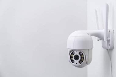 Antenli yuvarlak CCTV kamerası beyaz duvara video çekiyor. Görüntüleri kaydetmek ve yayınlamak için dijital ekipman