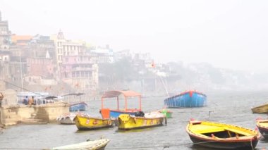Varanasi, Utter pradesh, Hindistan, 3 Ocak 2022, ghatlardan kutsal Varanasi şehri manzarası. Nehrin kıyısına demirlemiş tekneler.