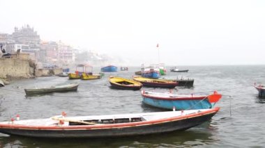 Varanasi, Utter pradesh, Hindistan, 3 Ocak 2022, ghatlardan kutsal Varanasi şehri manzarası. Nehrin kıyısına demirlemiş tekneler.