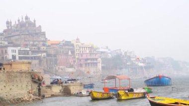 Varanasi, Utter pradesh, Hindistan, 3 Ocak 2022, ghatlardan kutsal Varanasi şehri manzarası. Nehrin kıyısına demirlemiş tekneler.