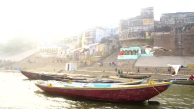 Varanasi, Utter pradesh, Hindistan, 3 Ocak 2022, ghatlardan kutsal Varanasi şehri manzarası. Nehrin kıyısına demirlemiş tekneler.