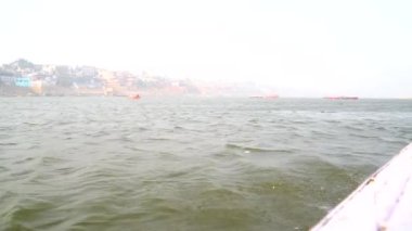 Varanasi, Utter pradesh, Hindistan, 3 Ocak 2022, ghatlardan kutsal Varanasi şehri manzarası. Nehrin kıyısına demirlemiş tekneler.