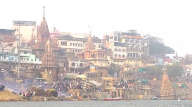 Varanasi, Utter pradesh, Hindistan, 3 Ocak 2022, ghatlardan kutsal Varanasi şehri manzarası. Nehrin kıyısına demirlemiş tekneler.