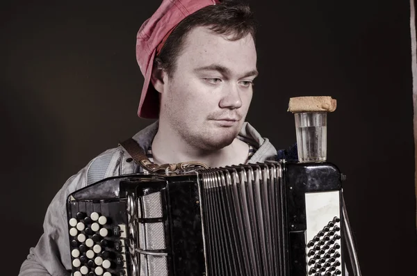 Russian poor man with an accordion and vodka — Stock Photo, Image