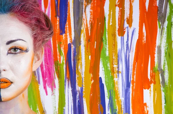 Femme avec visage peint sur un fond coloré Images De Stock Libres De Droits