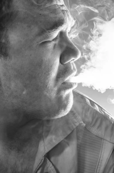 Sigara dumanı adamın yüzüne — Stok fotoğraf