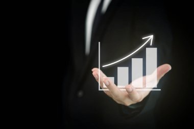 İş ve finansal büyüme kavramı. İş hayatında tanınmayan bir iş adamı. İş raporunda parmağıyla grafikleri işaret ediyor..
