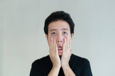 Yakışıklı, arka planda siyah tişörtlü gözlüklü, mutlu Asyalı genç adam. Asyalı genç adamın portresi.