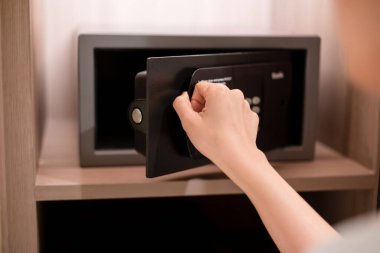 Tanınmayan Asyalı iş kadını kasa ya da kasayı açıyor. Konuklar ve müşteriler için lüks oteldeki güvenli depo. Değerli eşyalarını güvende tut..