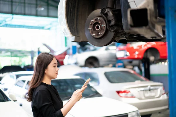 Asiatische Junge Frau Schwarzem Hemd Begutachtet Eine Fahrzeugaufhängung Und Bremsanlage — Stockfoto