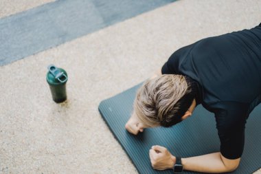 Aktif Asyalı genç adam vücut ağırlığı egzersizini yakın mesafeden yapıyor sporcu ise şınav ve kalasla vücut ağırlığı egzersizi yapıyor. Asyalı sporcu kas ve vücut geliştirme egzersizi yapıyor..