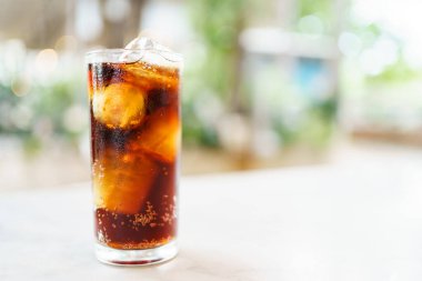 İçki bardağında buzlu kola sodası ile yakın çekim yap. Köpüklü kola bardağı buzla doldurdu..